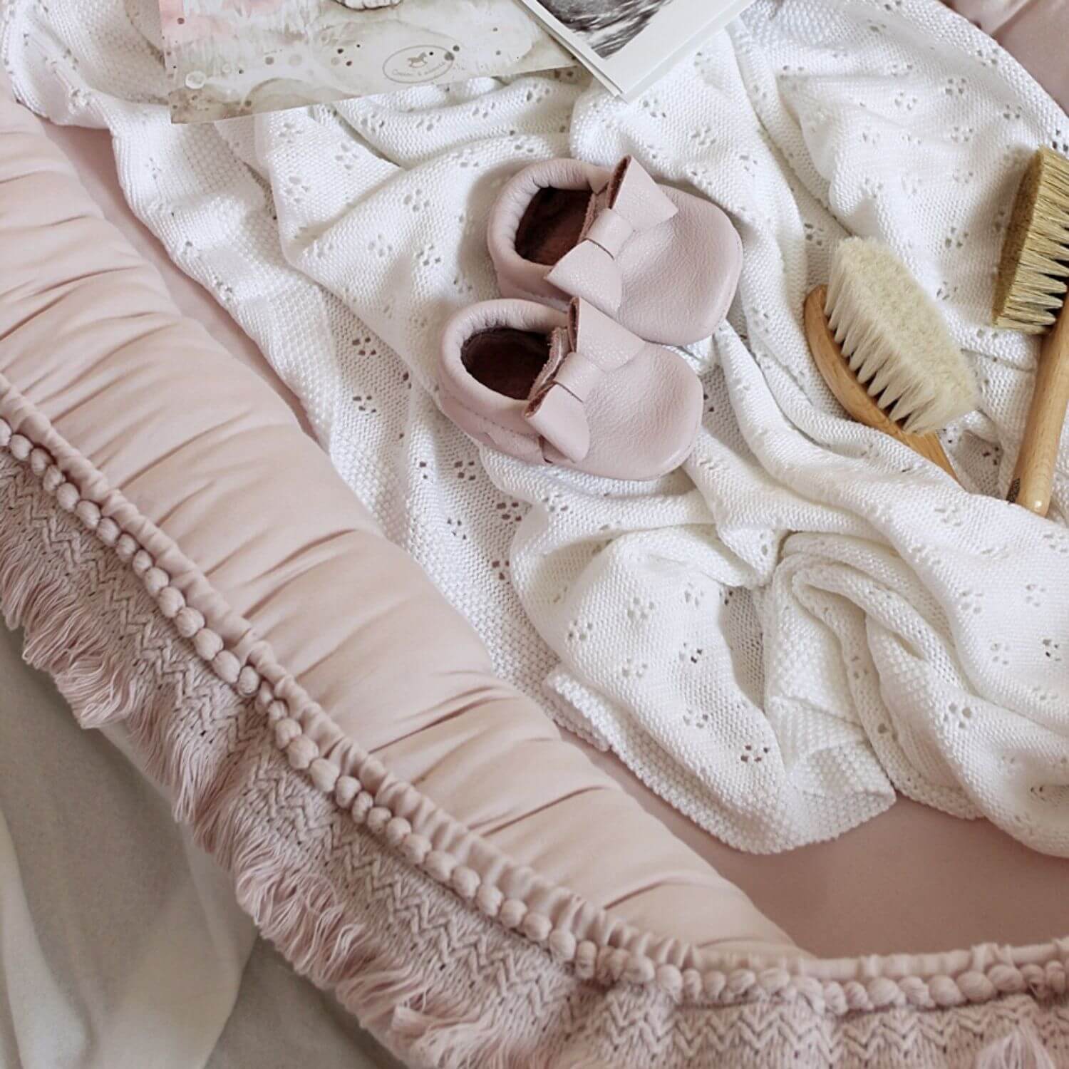 roze boho babynestje met franjes en babyspulletjes Sassefras